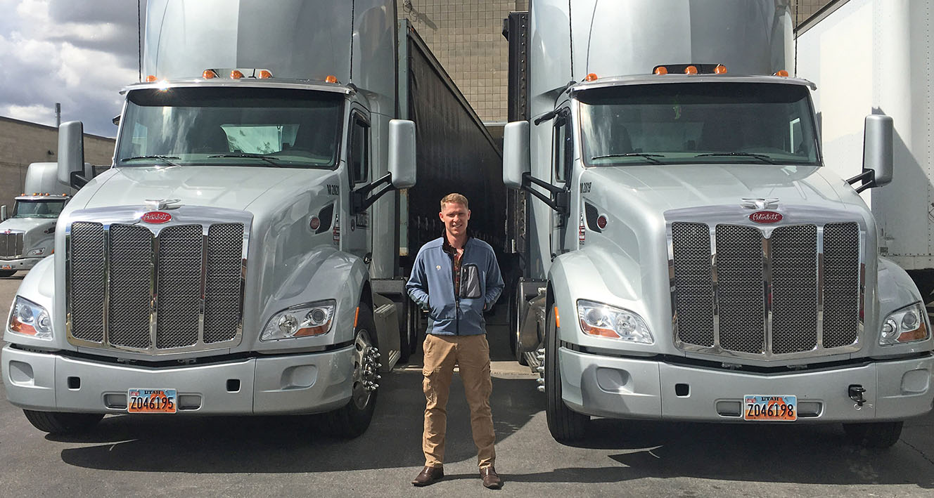 Adam Jensen in front of 2 Peterbilt Model 579s